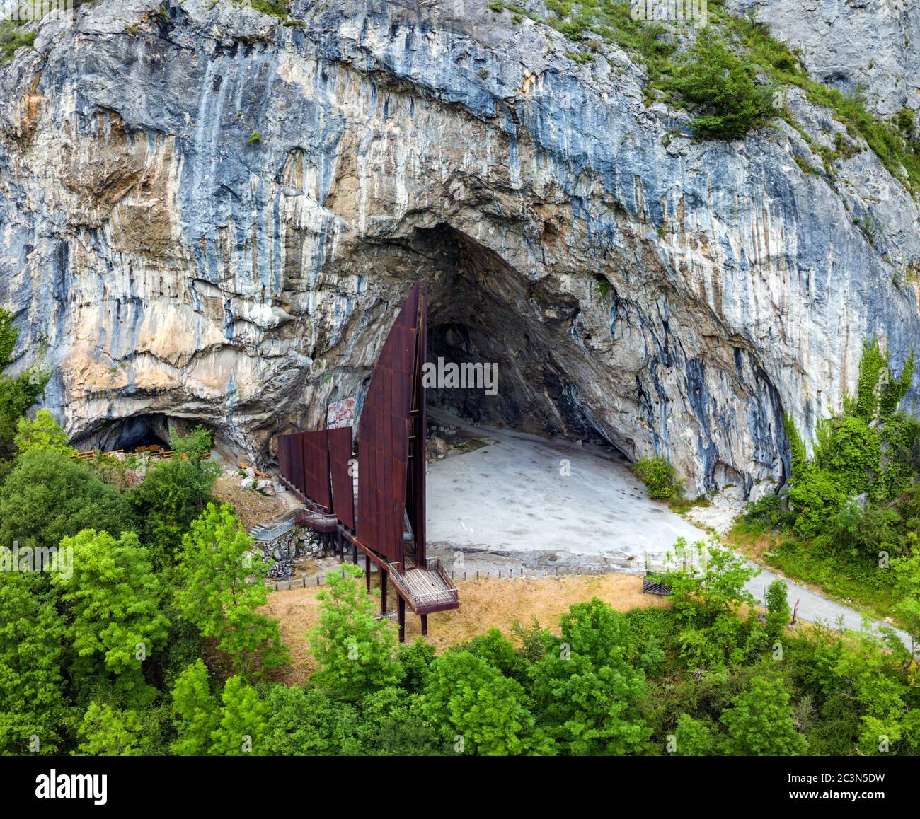 The large entrance to Niaux Cave with its iron sculpture, Niaux, Ariege, France Stock Photo