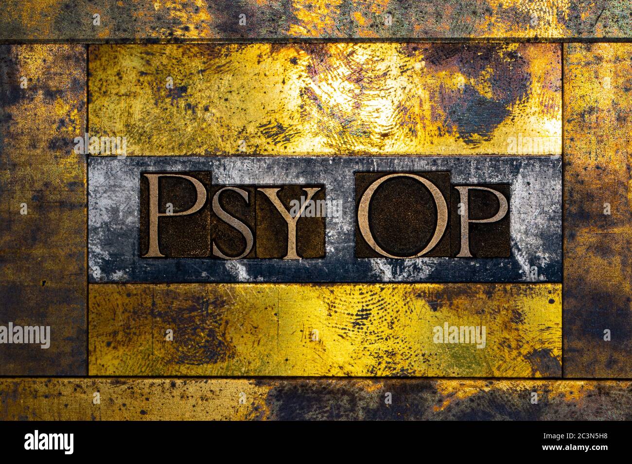Psy Op text formed with real authentic typeset letters on vintage textured silver grunge copper and gold background Stock Photo
