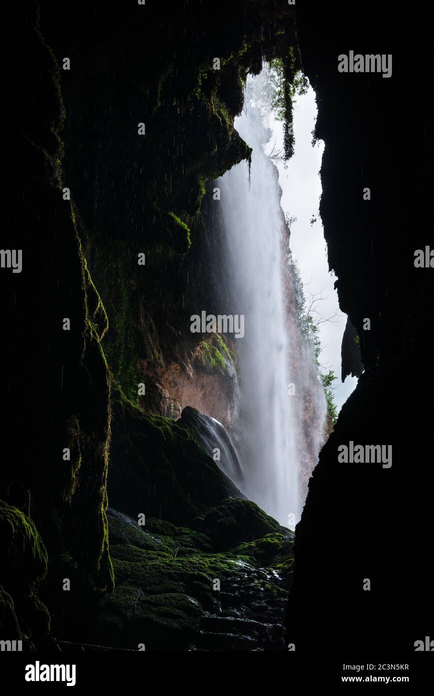Flowing water of a high waterfall on the Piedra River in Aragon, Spain, as seen from inside a cave. Stock Photo