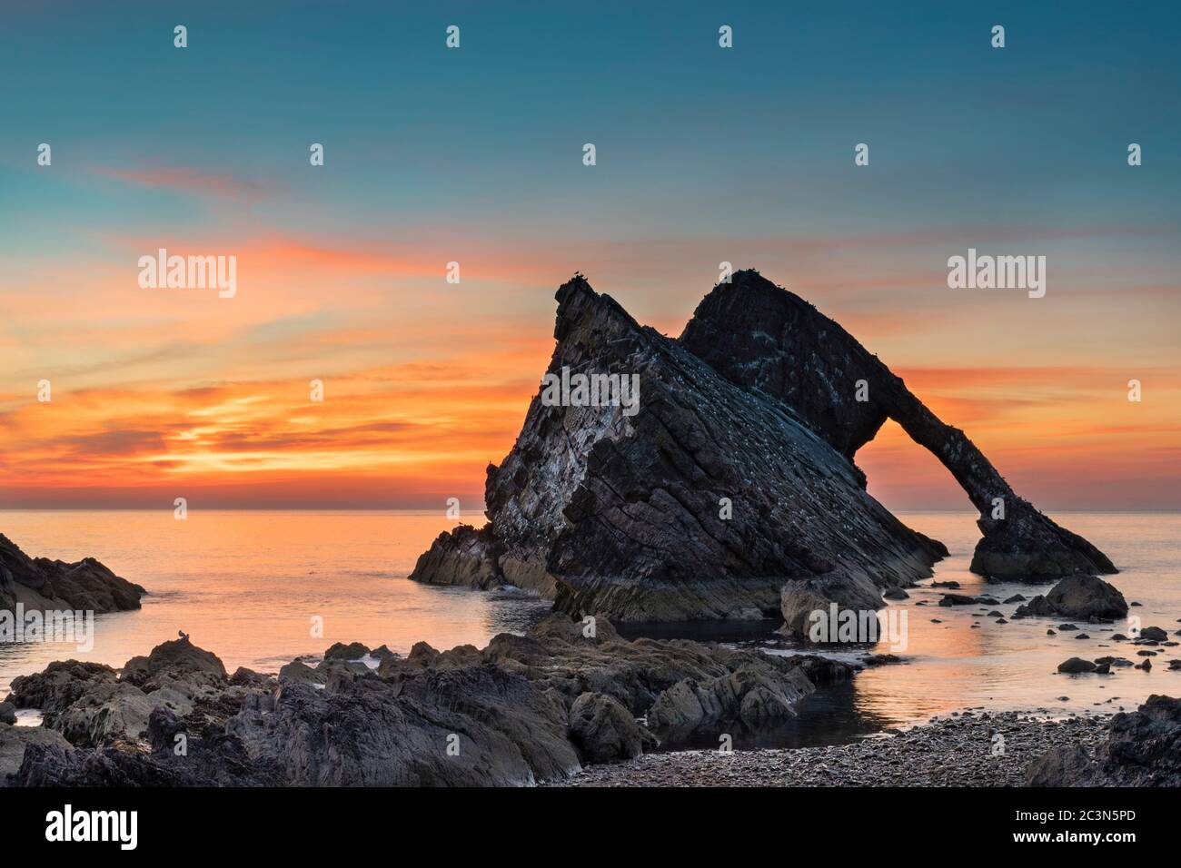 BOW FIDDLE ROCK PORTKNOCKIE MORAY COAST SCOTLAND LATE JUNE AND A LOW TIDE SUNRISE OVER THE ROCKS Stock Photo