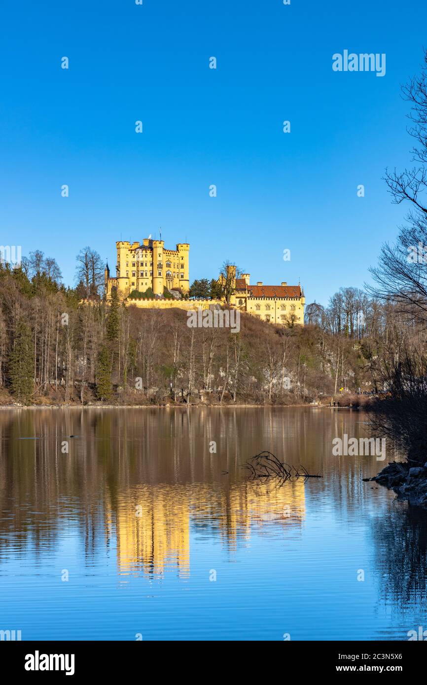 Stunning view of the Alpsee lake in winter on a sunny day with the Hohenschwangau Castle and Bavaria Alps in background, with beautiful reflections in Stock Photo