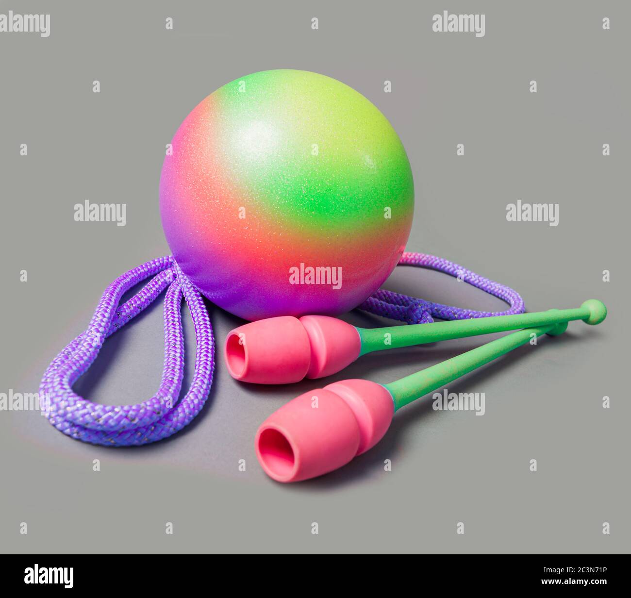 Rhythmic gymnastics equipment on grey background. Green ball, mace and rope for gymnastics Stock