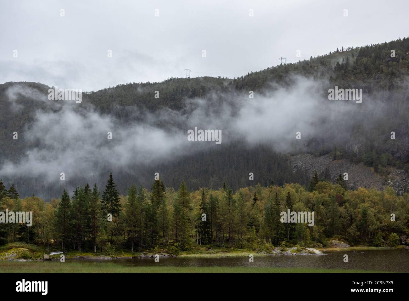 Clouds on lake in Norway mountains. Autumn travel wild nature. Foggy scandinavia cloudy pine forest Stock Photo
