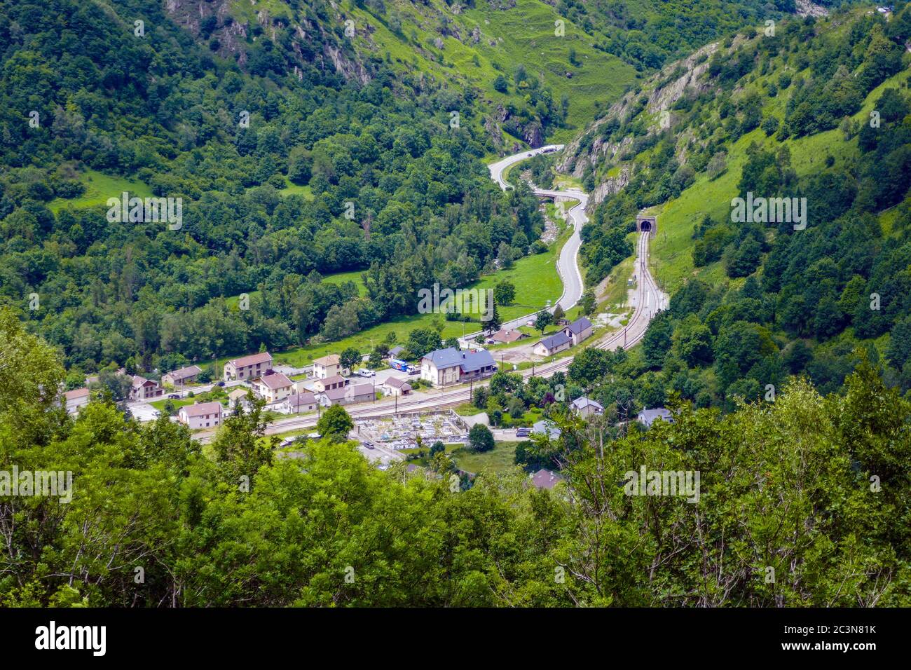 Road and railway through the tiny village of Merens-les-Vals, Ariege, French Pyrenees, France Stock Photo