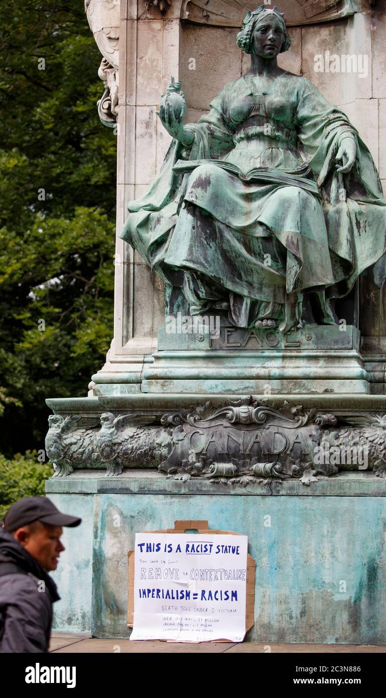 A sign left on a statue of Queen Victoria located near a Black Lives