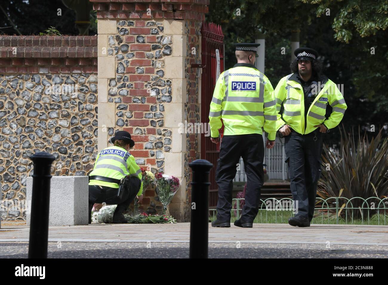 Police move flowers from Abbey Gate closer to the entrance at Forbury Gardens in Reading town centre at the scene of a multiple stabbing attack which took place at around 7pm on Saturday leaving three people dead and another three seriously injured. Stock Photo