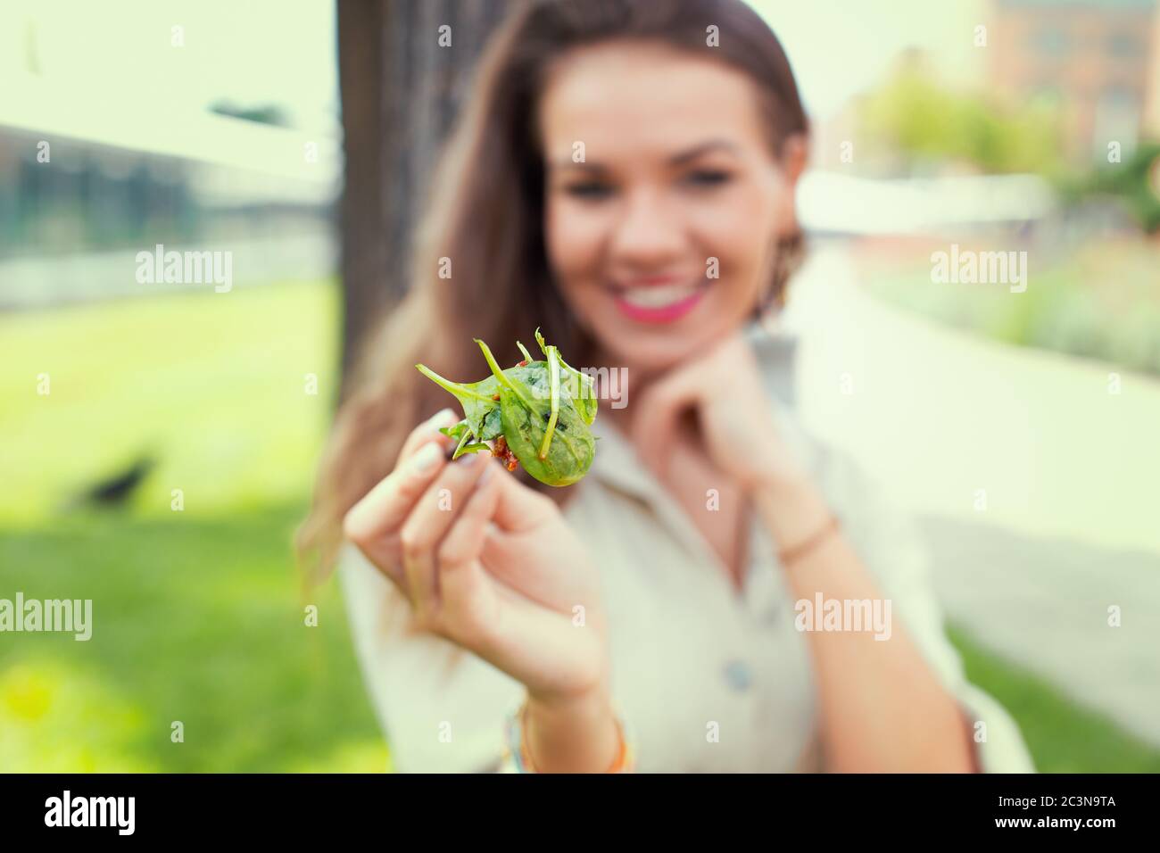 Happy young latina woman offering salad, depth of field Stock Photo