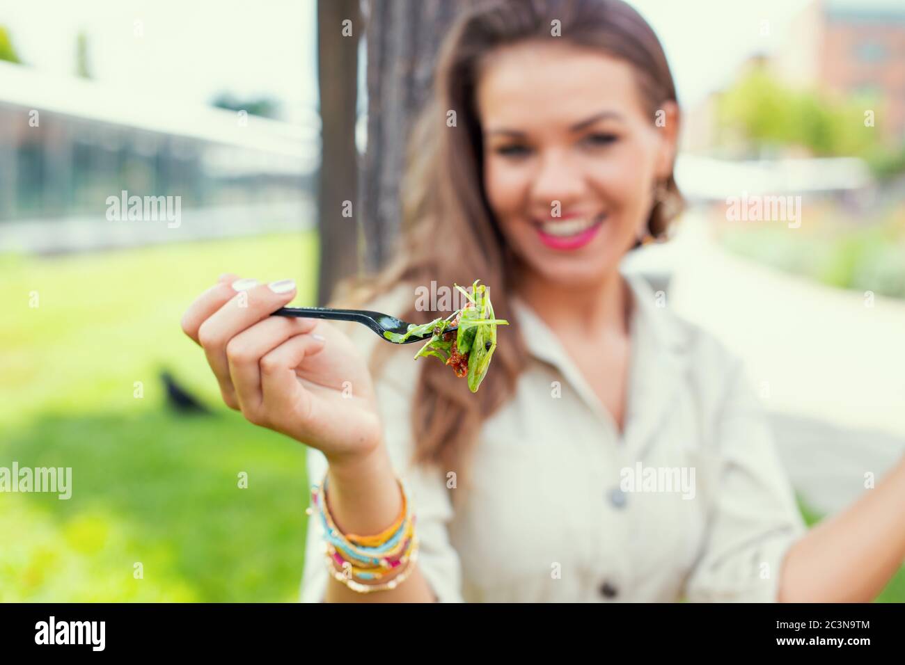 Young cheeerful latina woman holding salad, depth of field Stock Photo