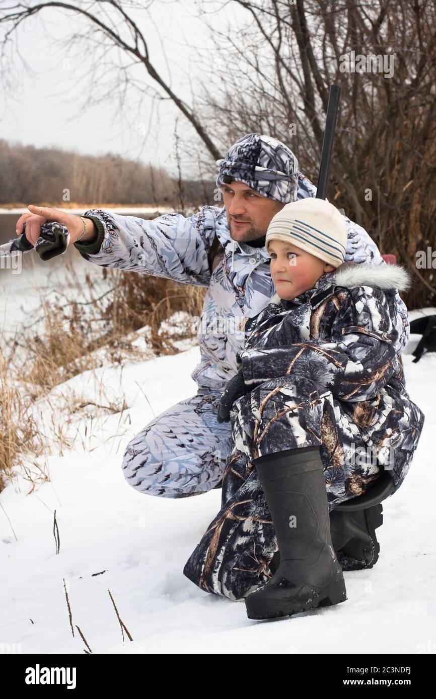 hunter shows his son where the prey on the river Stock Photo