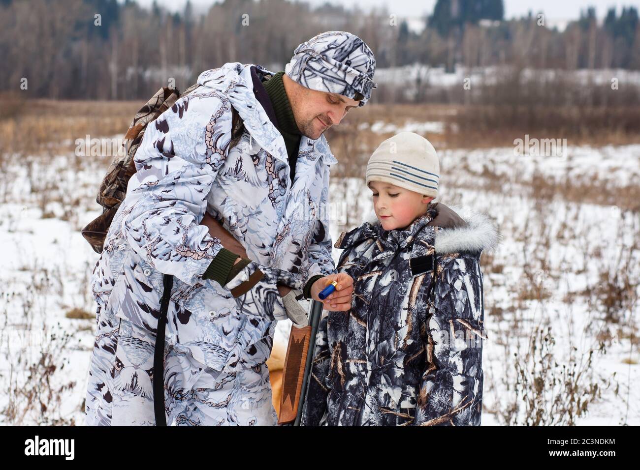 hunter with his son on winter hunting Stock Photo