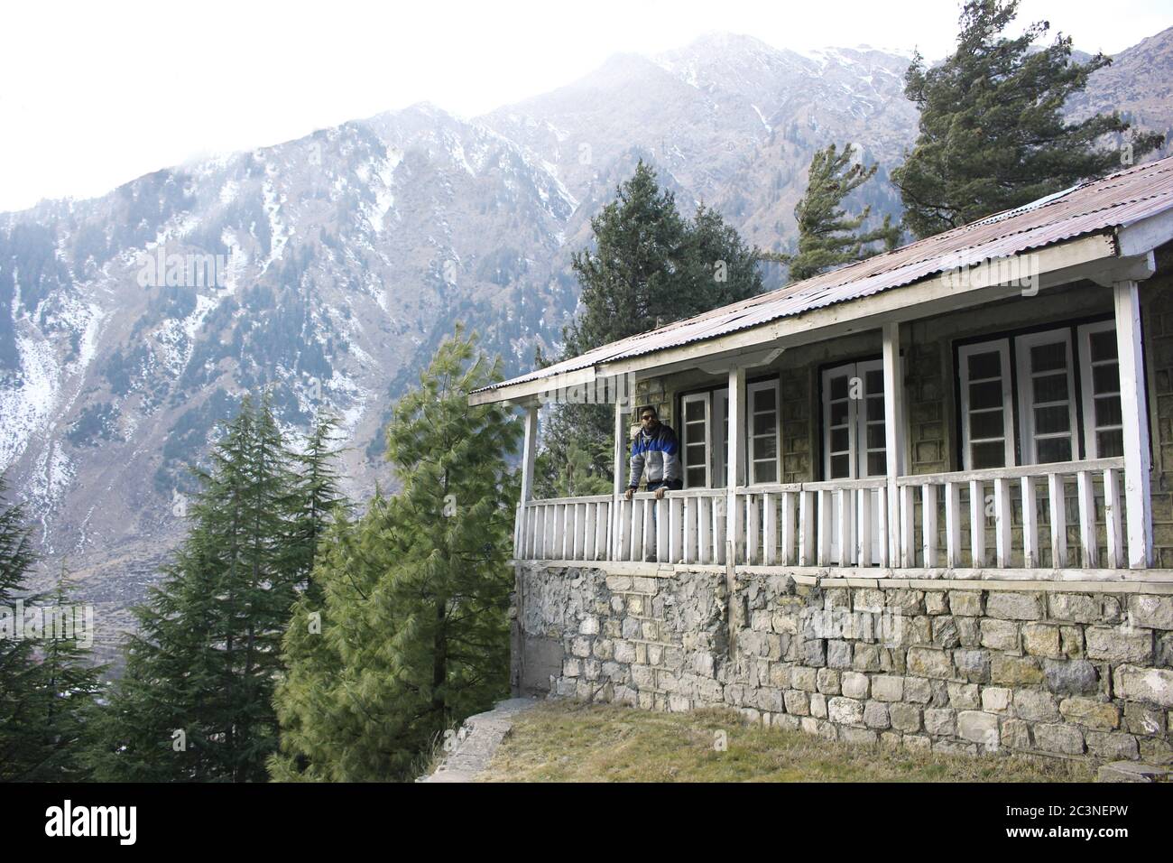 Guy standing on terrace of a cottage in mountain of Naran Valley, KPK, Pakistan Stock Photo