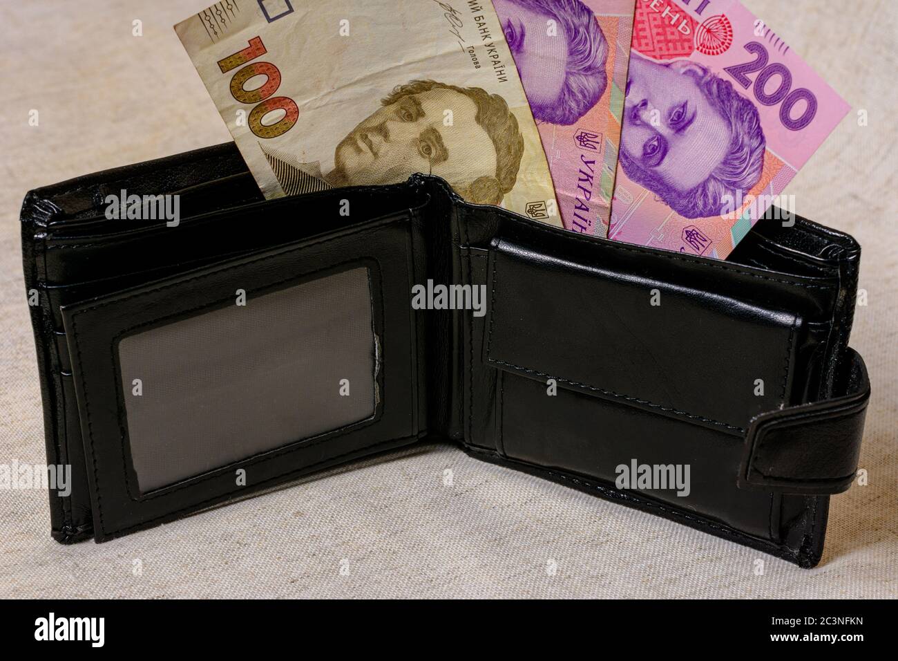 100 and 200 hryvnia in a black wallet on a gray background. Stock Photo