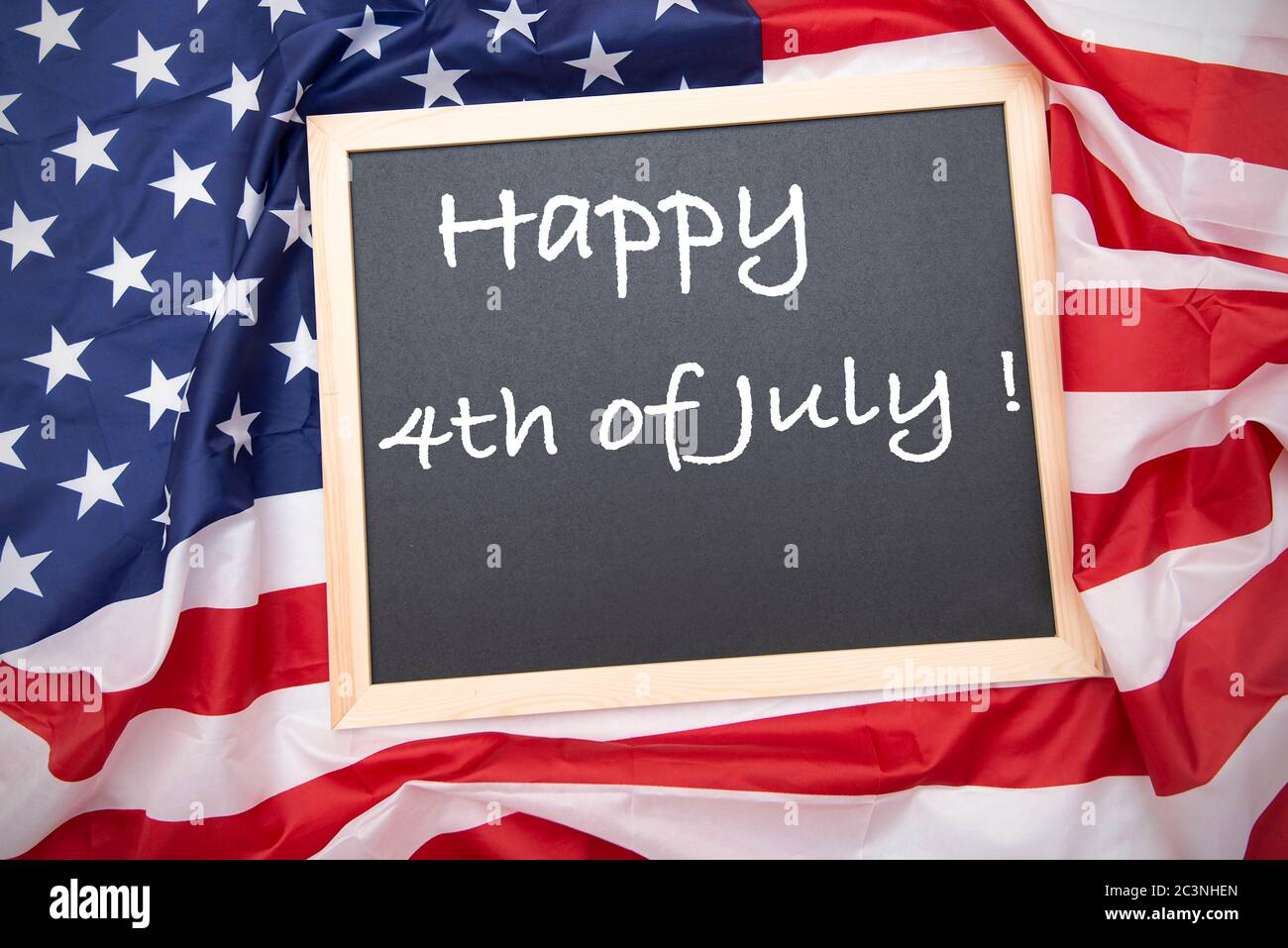 Fabric USA flag with chalkboard and text Happy 4th of July - Independence Day Stock Photo