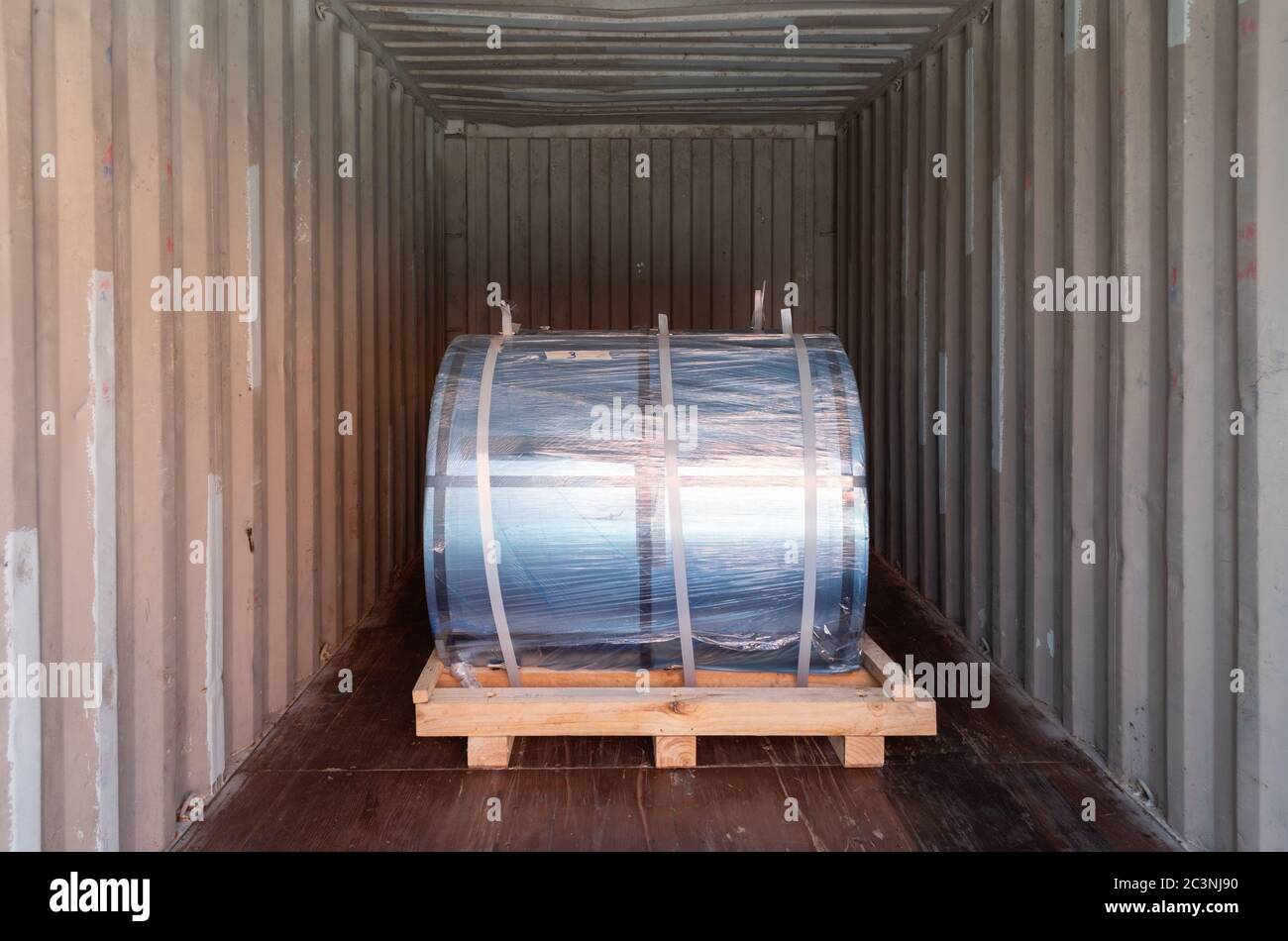 Steel coils container stuffing for export, steel coils on wooden pallets inside container. Steel product import export. Container stuffing and unstuff Stock Photo