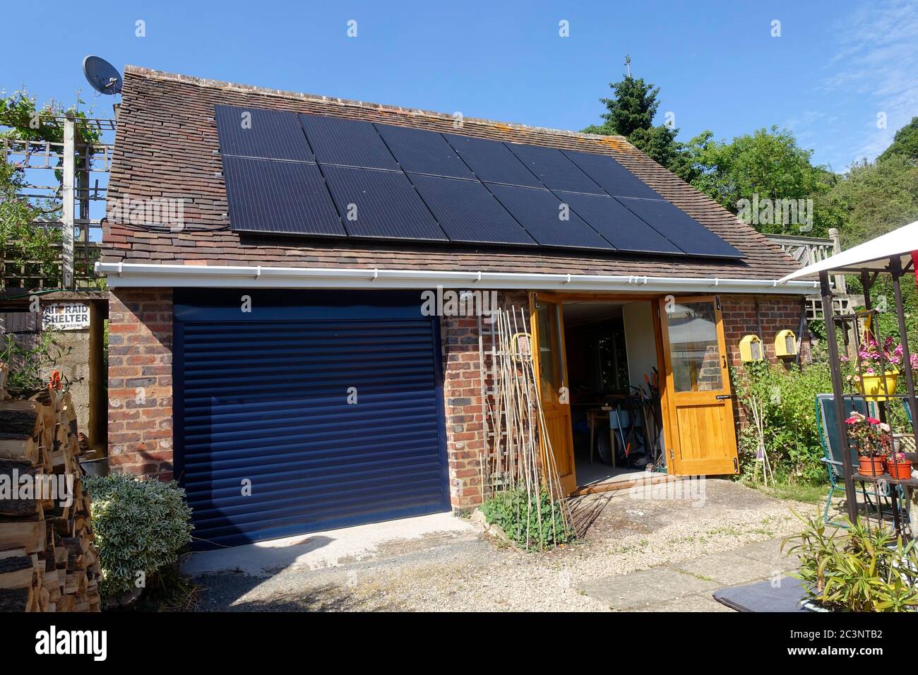 Black solar photovoltaic PV panels installed on garage rook, Bewdley