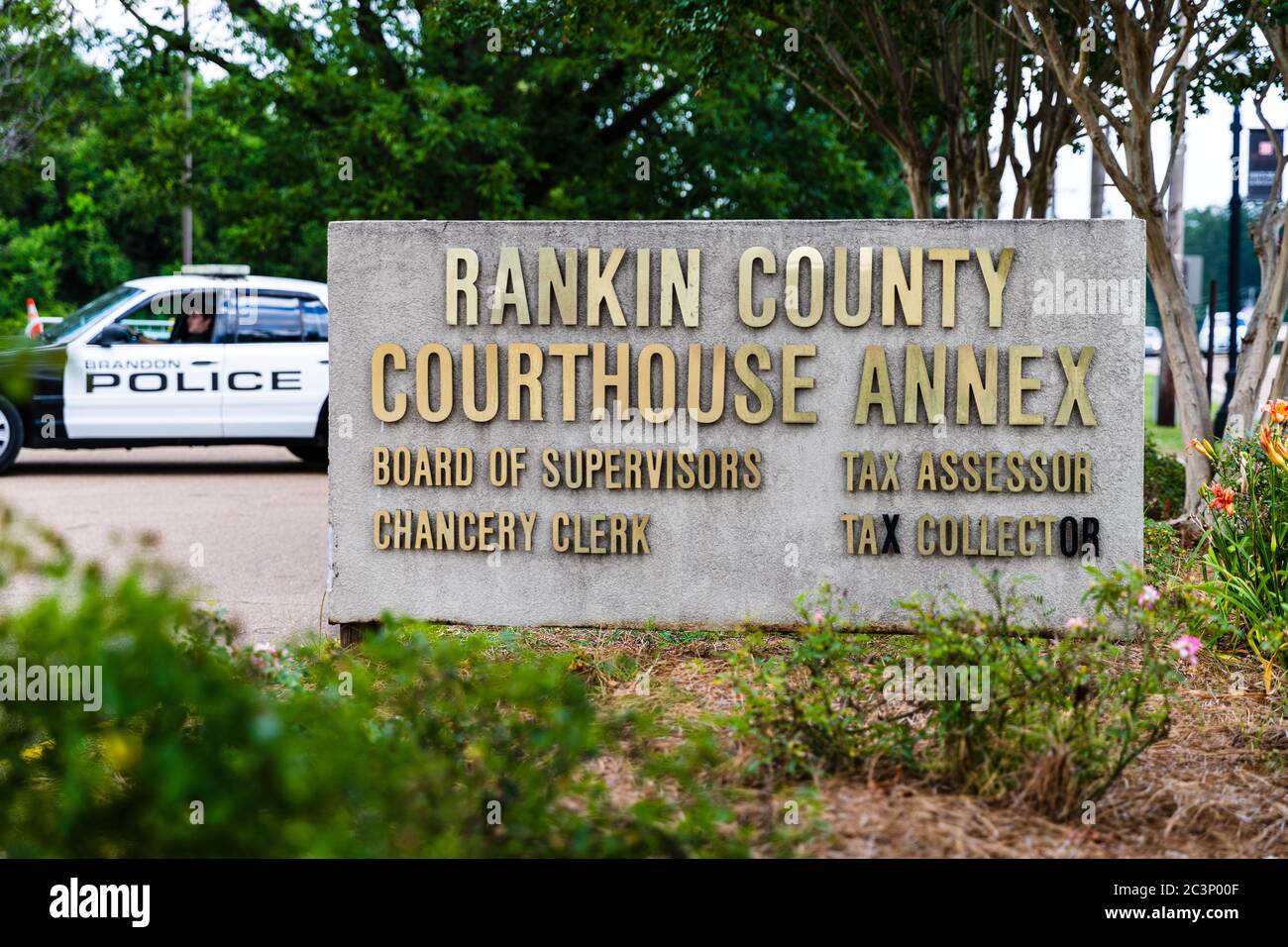 Brandon, MS / USA - June 20, 2020: Rankin County Courthouse Annex sign in downtown Brandon, MS, with police car in background Stock Photo