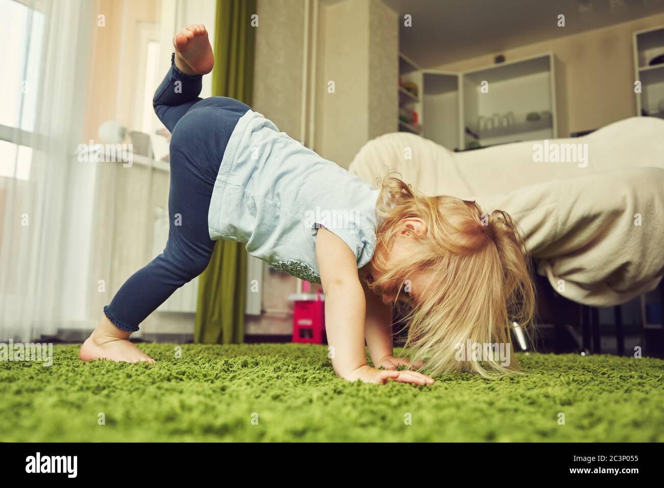 funny little girl doing yoga. child playing at home Stock Photo - Alamy