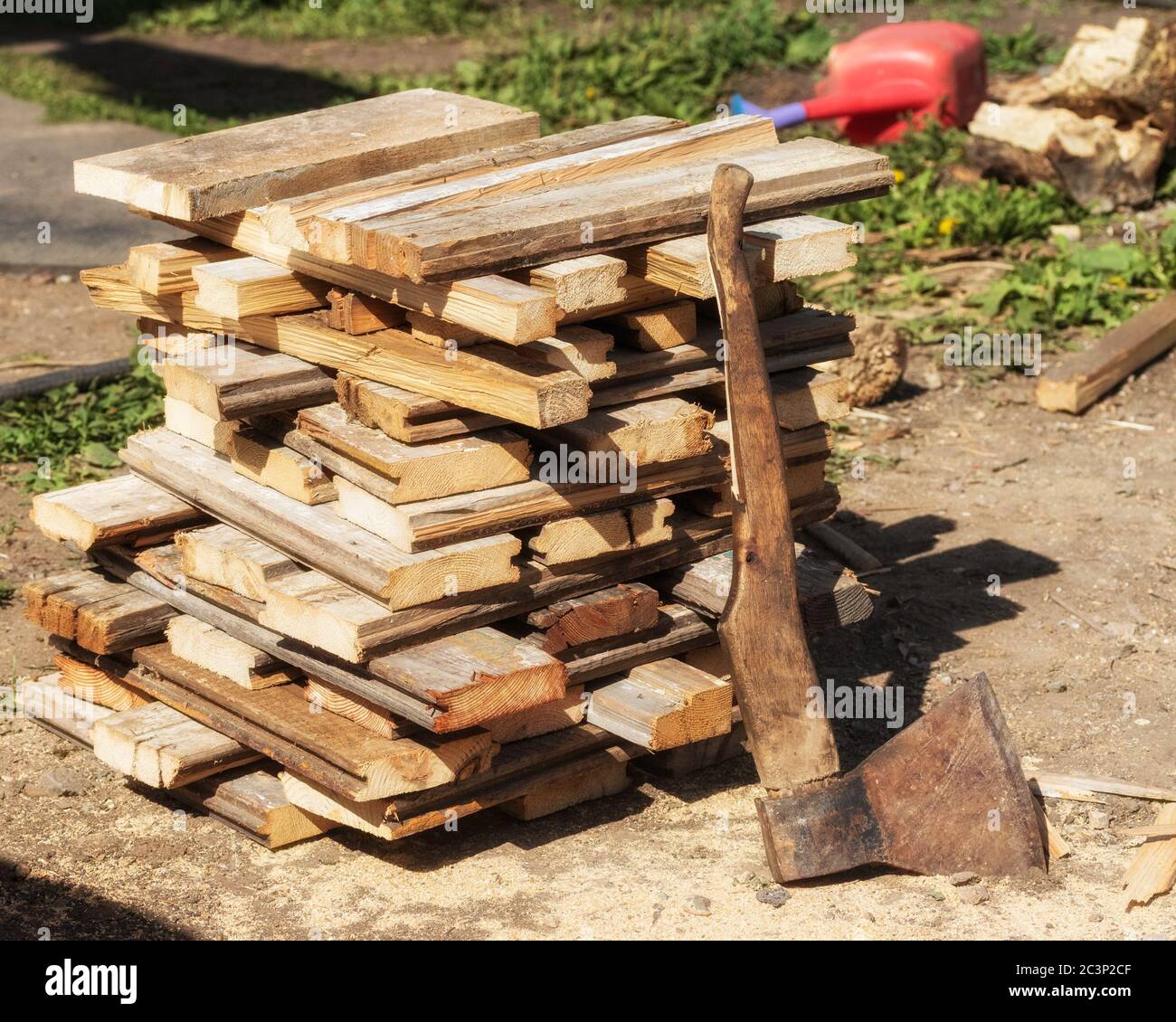 There is wood on the ground, an axe is attached to the pole. The photo was taken at a cottage in Chelyabinsk, Russia. Stock Photo