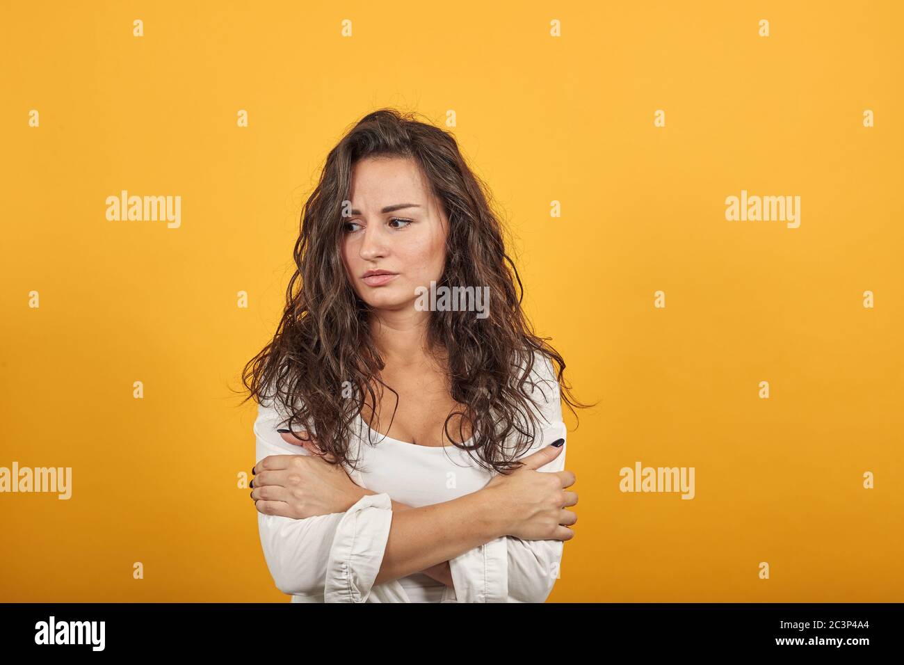 Hugging herself to warm while feeling cold arms crossed fear expression on face Stock Photo Alamy