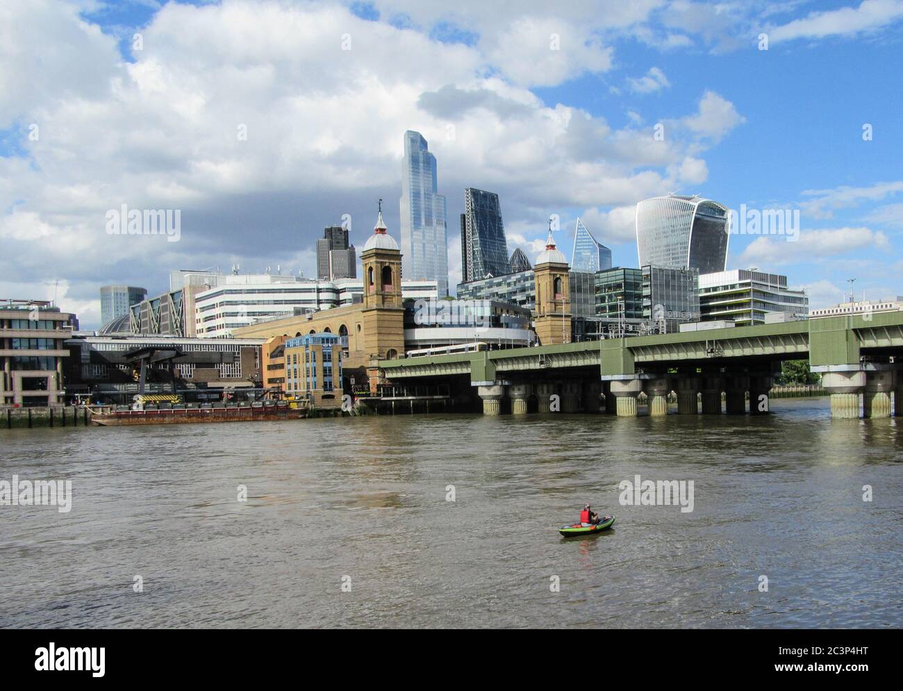 London Uk 21 June 2020 A sole canoeist have the river thames all to himself to enjoy a sunny day with the City of London in his background..Paul Quezada-Neiman/Alamy Live News Stock Photo