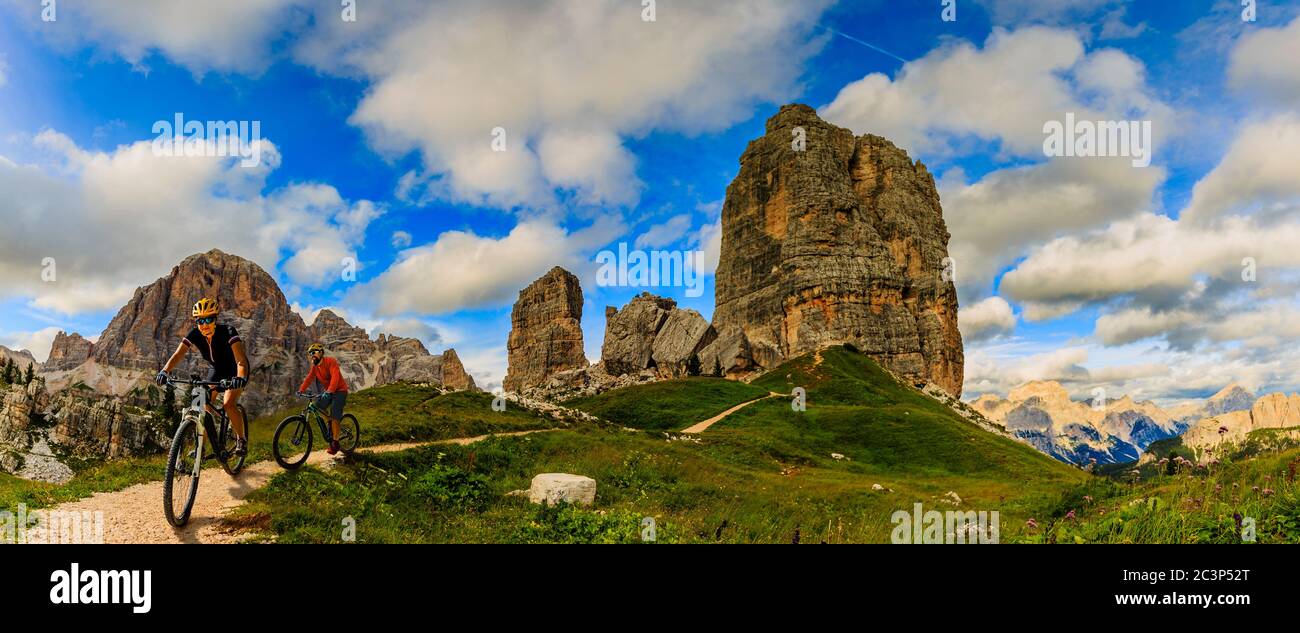 View of cyclist riding mountain bike on single trail in Dolomites, Cinque Torri, South Tirol, Italy Stock Photo