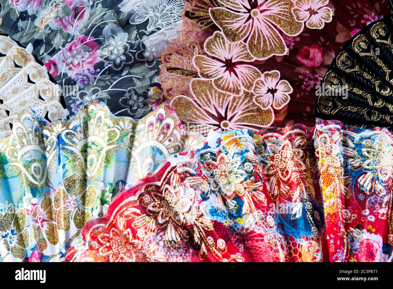 Flamenco hand fans with colorful floral pattern bunched together for