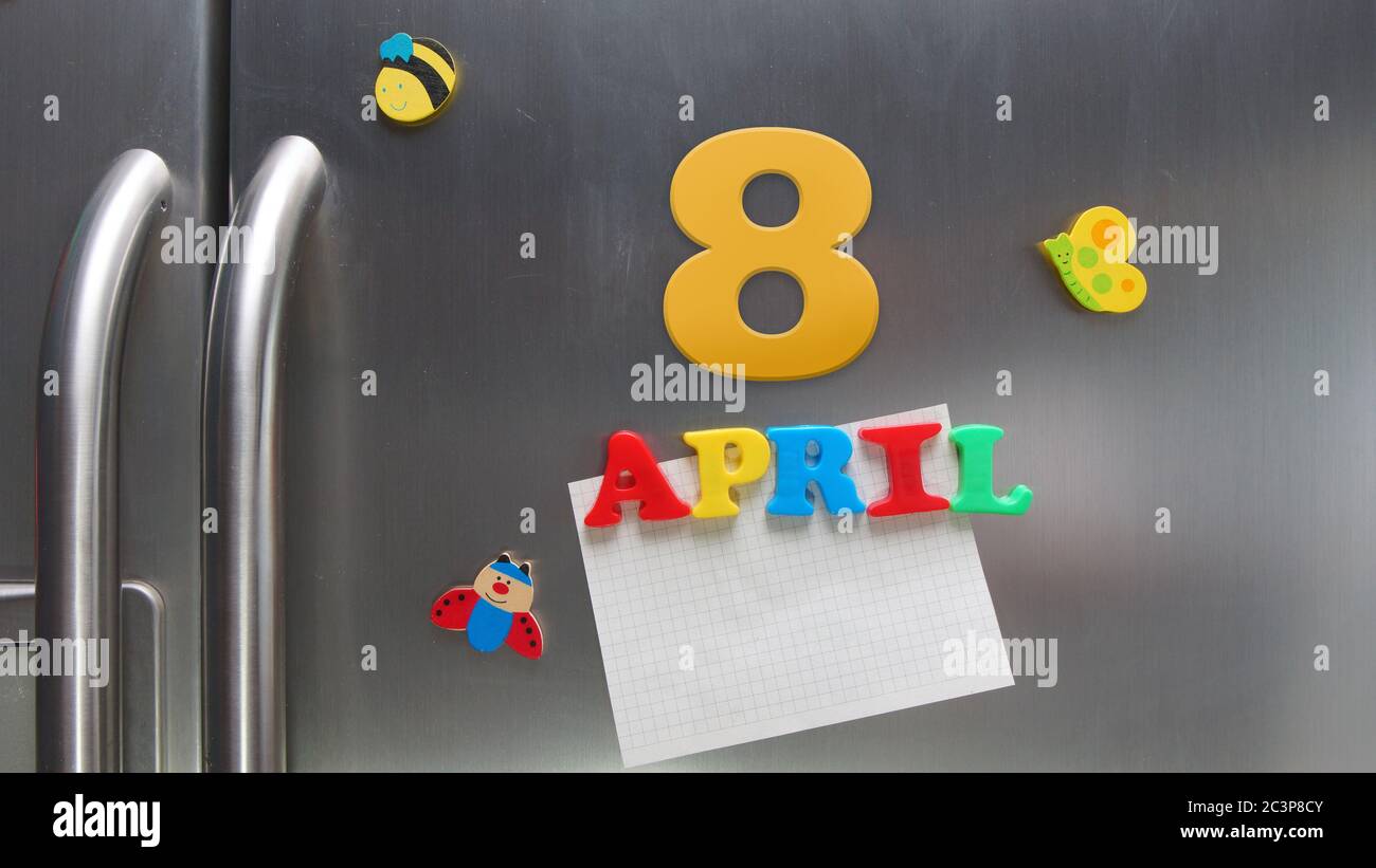 April 8 calendar date made with plastic magnetic letters holding a note of graph paper on door refrigerator Stock Photo