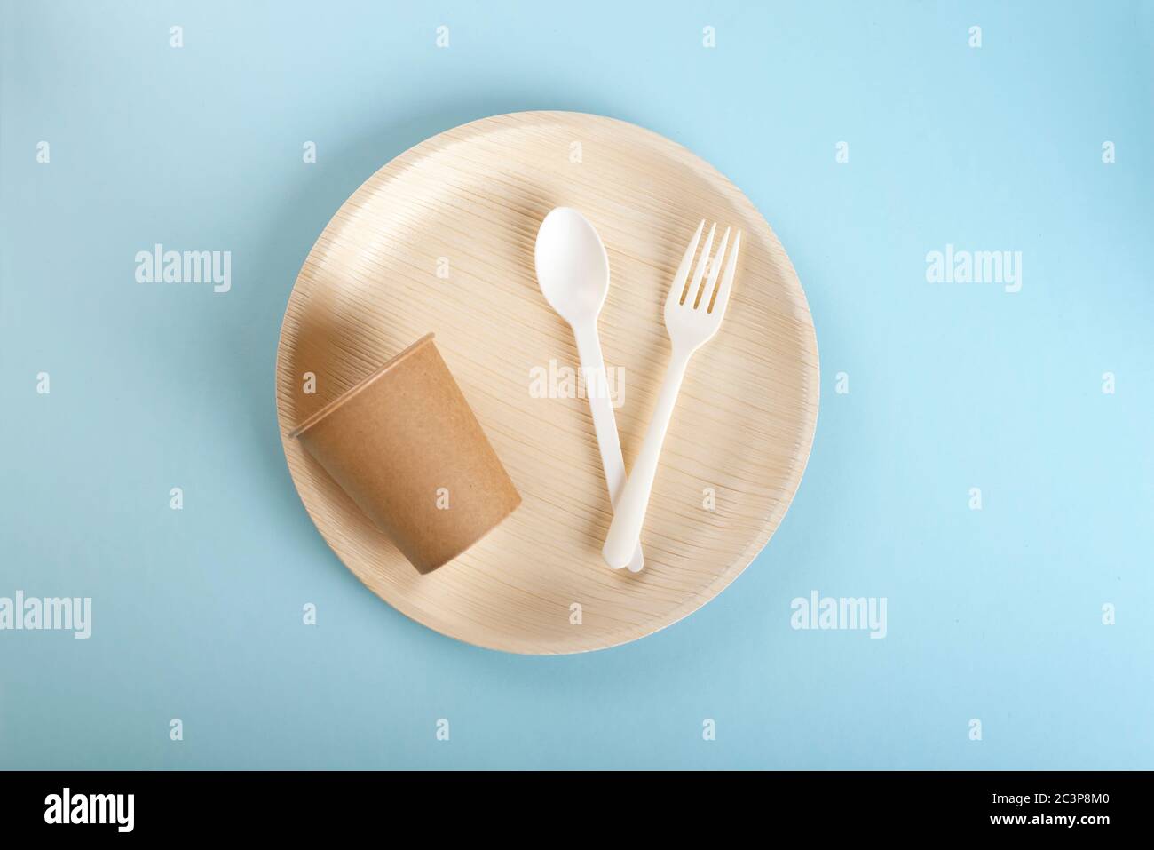 A set of disposable plate, disposable cup, fork and spoon on light blue background Stock Photo