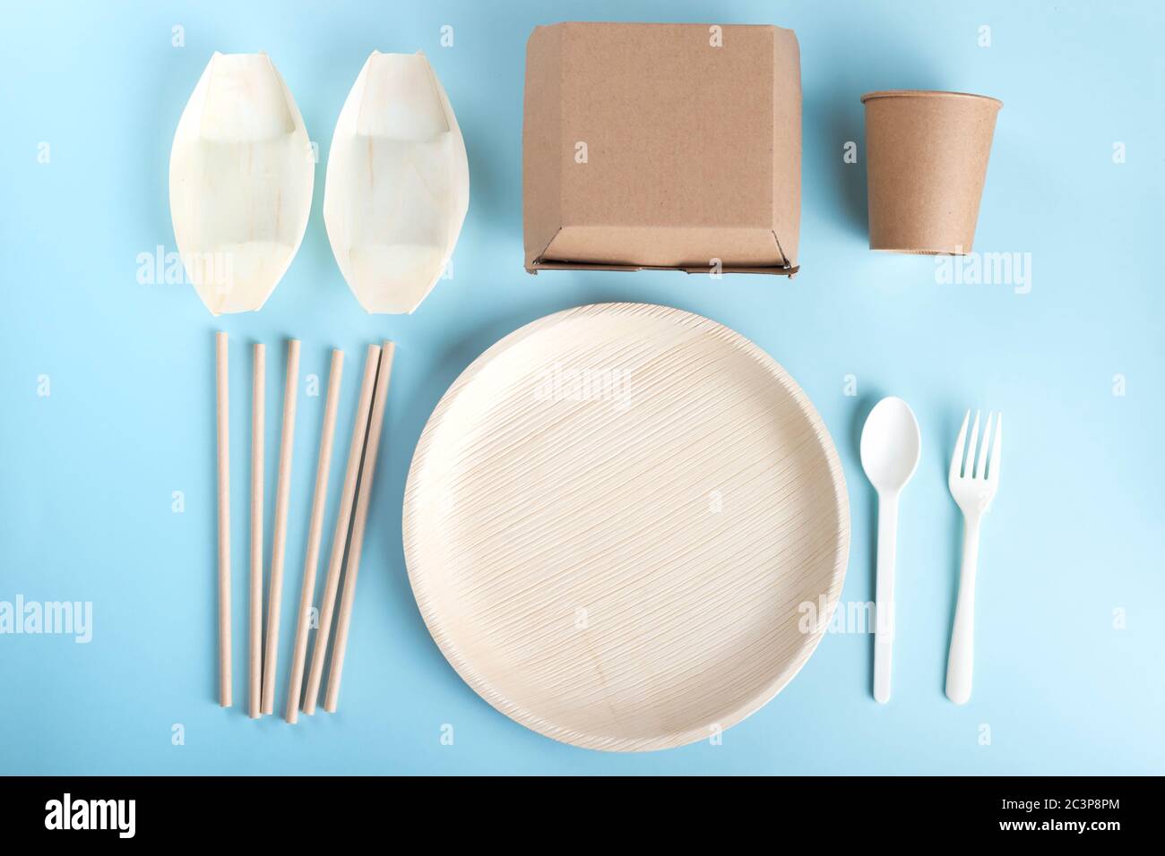 Eco friendly disposable tableware flat lay on light blue background ...