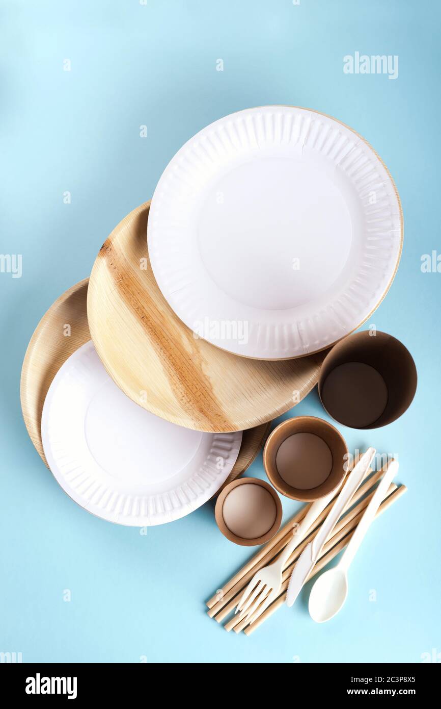 Eco friendly disposable tableware flat lay on light blue background.  Stock Photo
