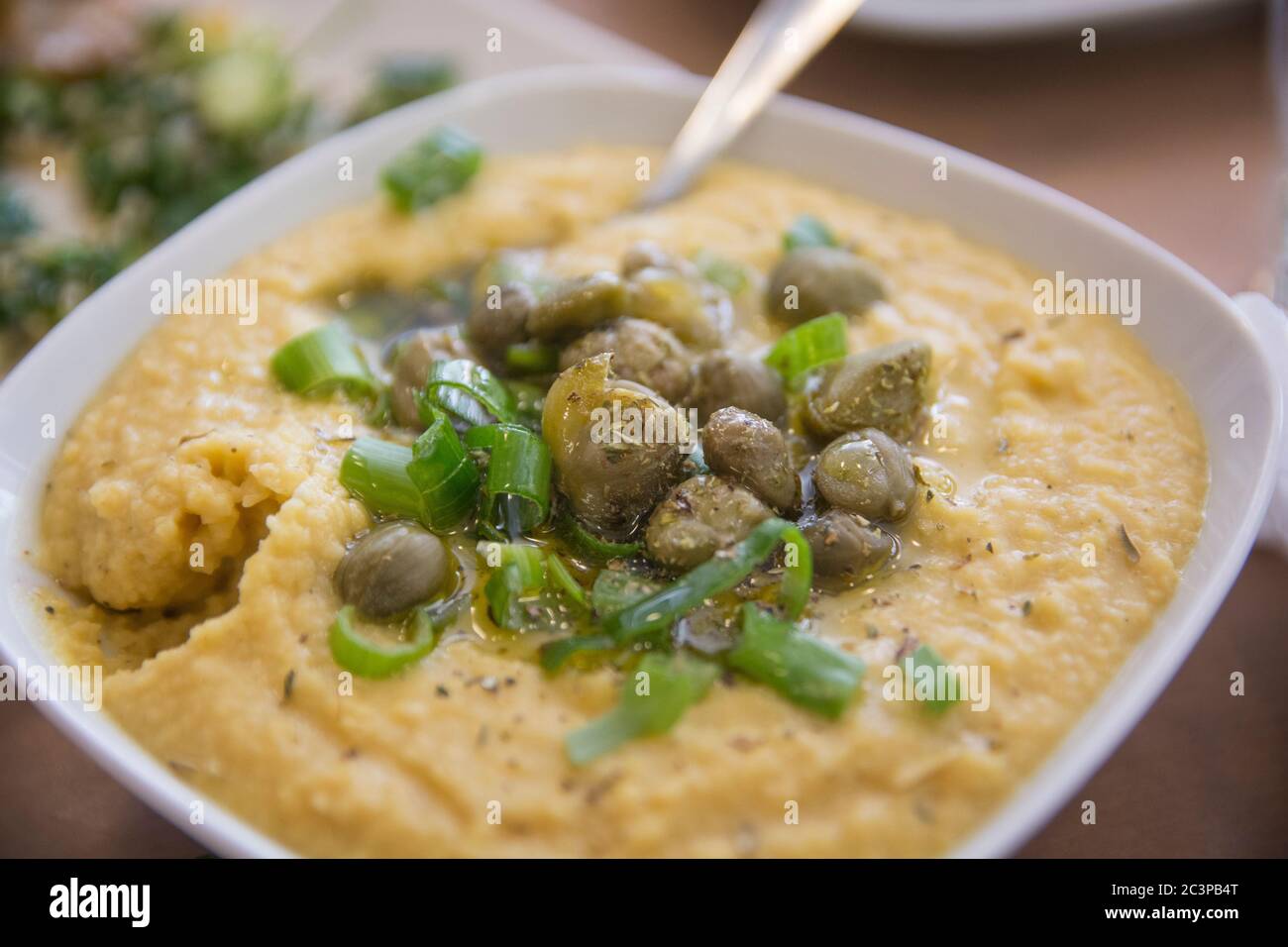 A bowl of traditional Greek Fava Puree of Yellow split peas, served with Capers and scallion
