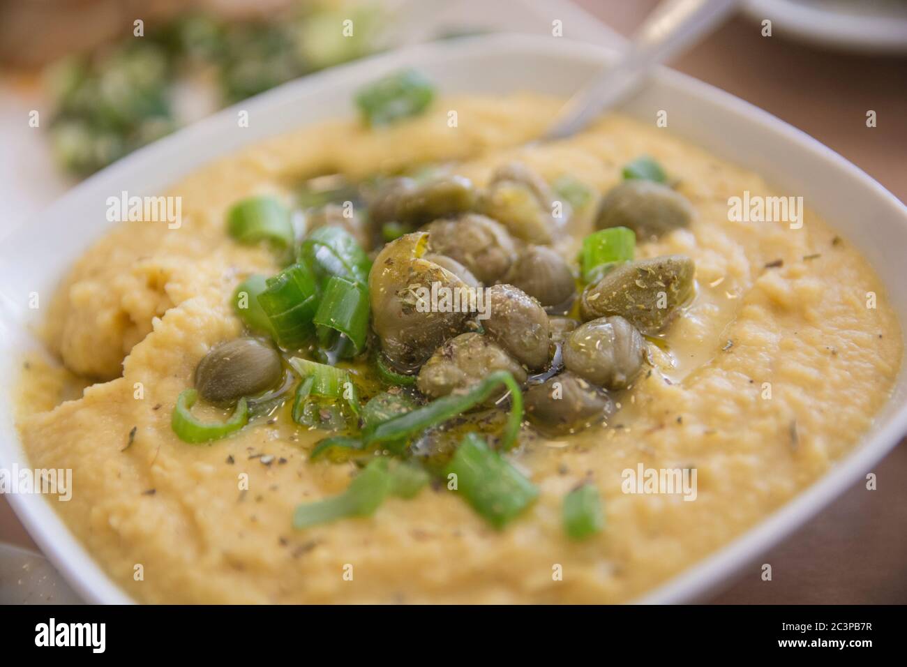 A bowl of traditional Greek Fava Puree of Yellow split peas, served with Capers and scallion