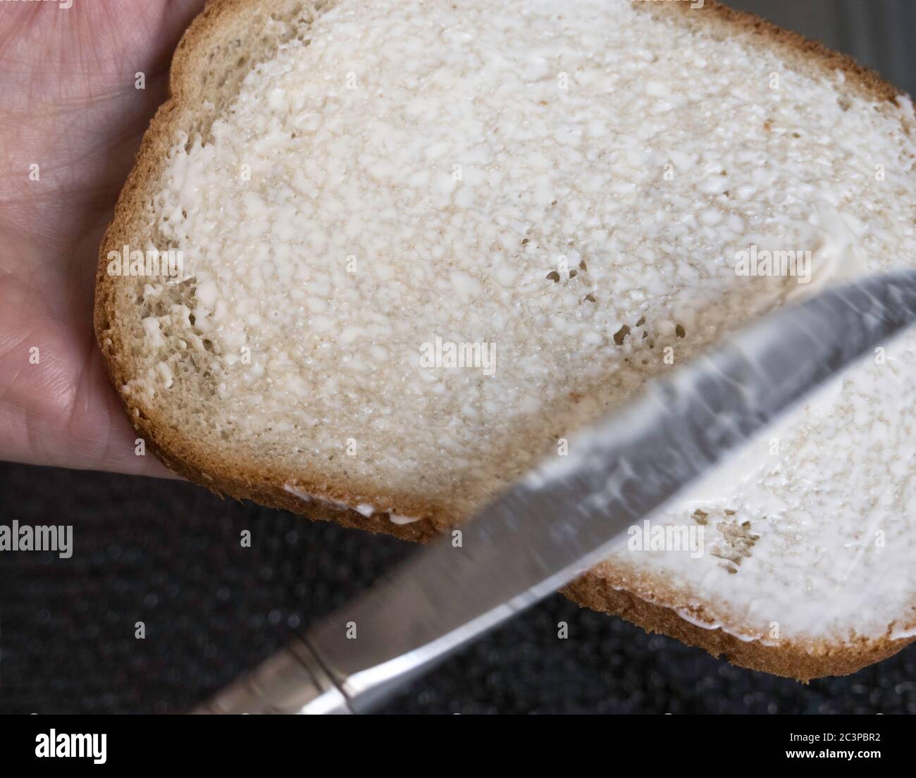Knife spreading mayonnaise on rye bread, USA Stock Photo Alamy