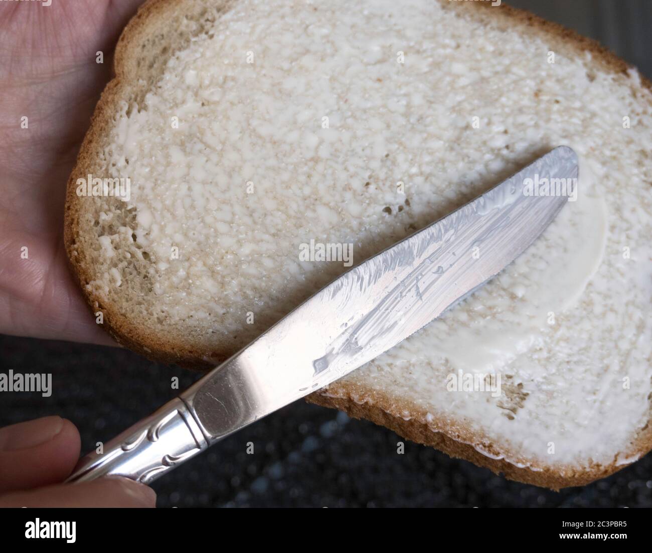 Knife spreading mayonnaise on rye bread, USA Stock Photo Alamy