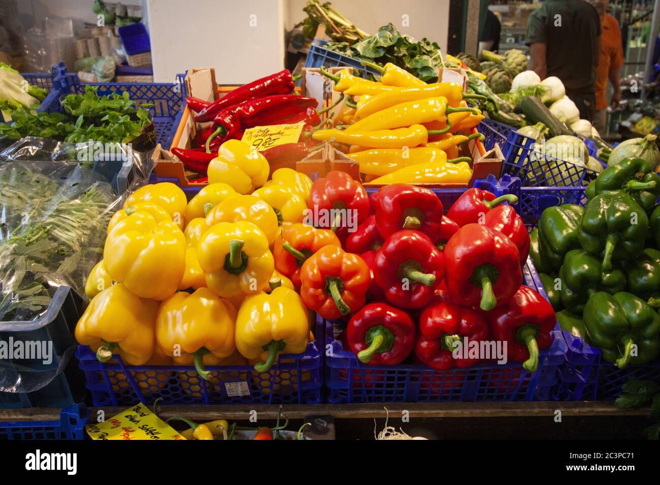 Closeup shot of colorful peppers in blue baskets on a market shelf ...