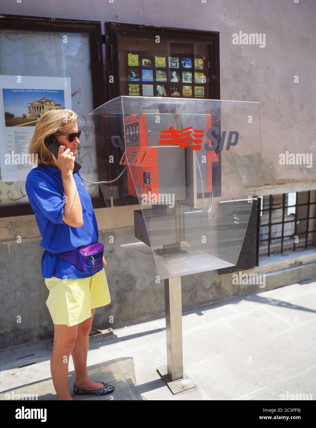 Young tourist woman using pay phone, Venice (Venezia), Veneto Region, Italy Stock Photo