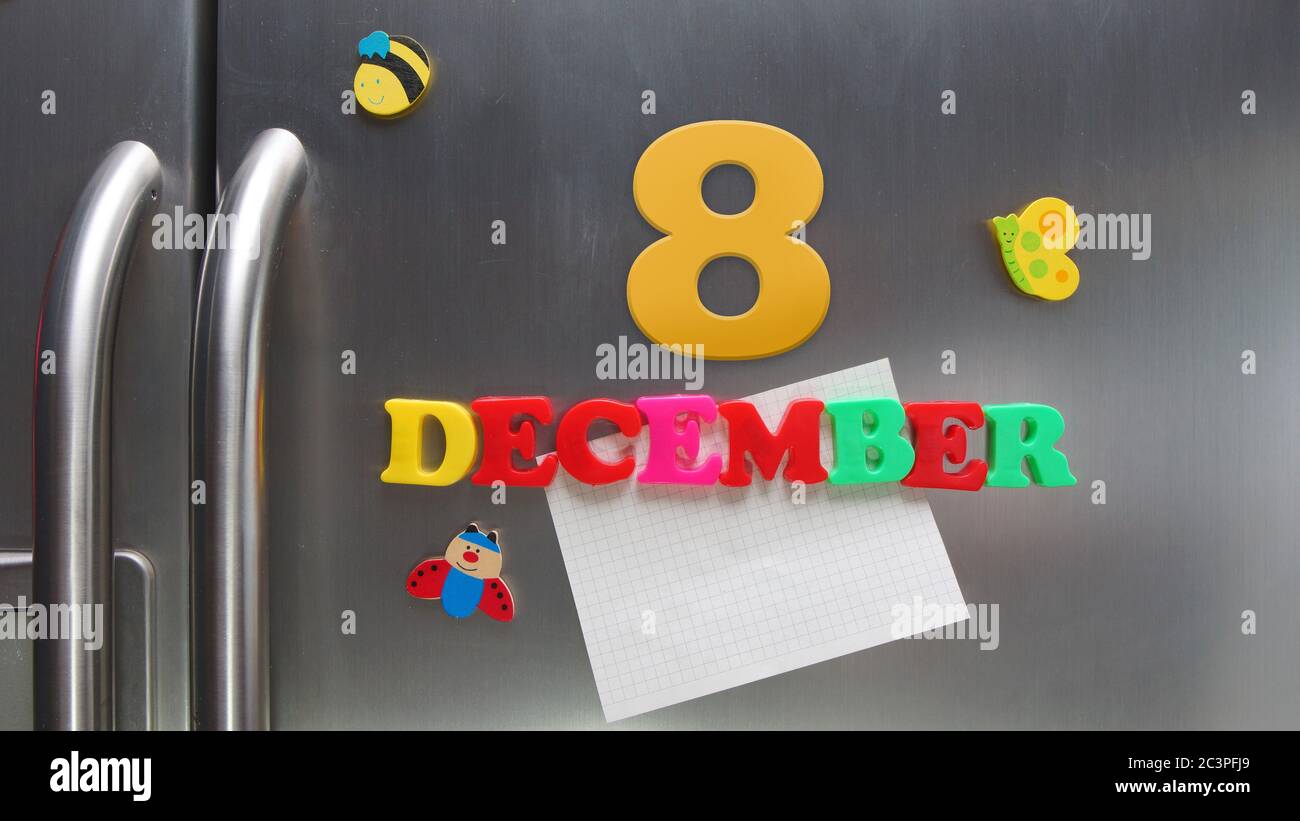 December 8 calendar date made with plastic magnetic letters holding a note of graph paper on door refrigerator Stock Photo