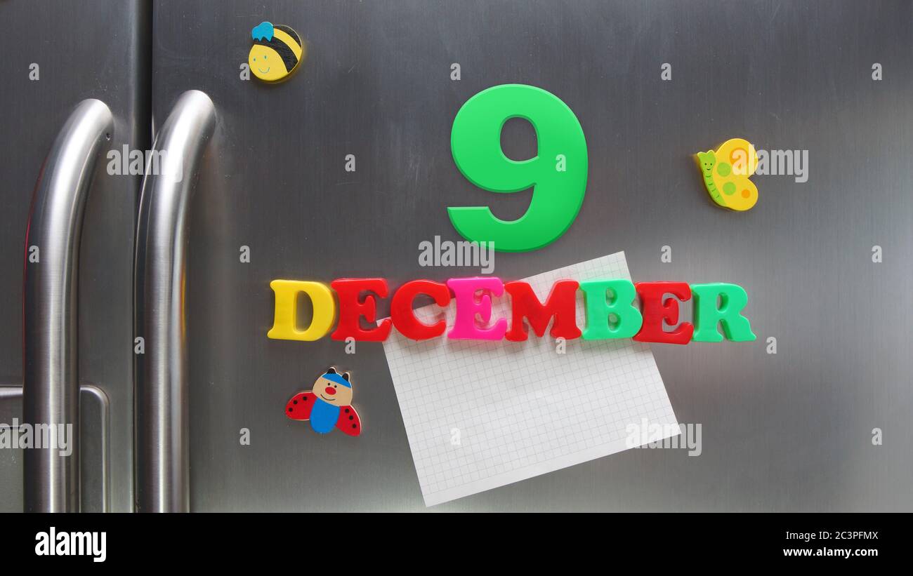 December 9 calendar date made with plastic magnetic letters holding a note of graph paper on door refrigerator Stock Photo