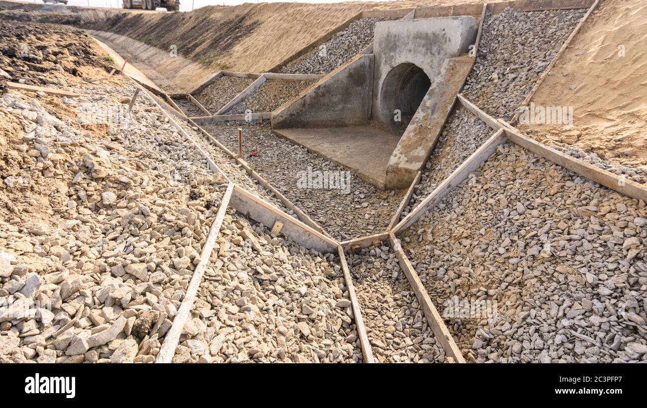 Construction of a drainage ditch along a road with a culvert under the