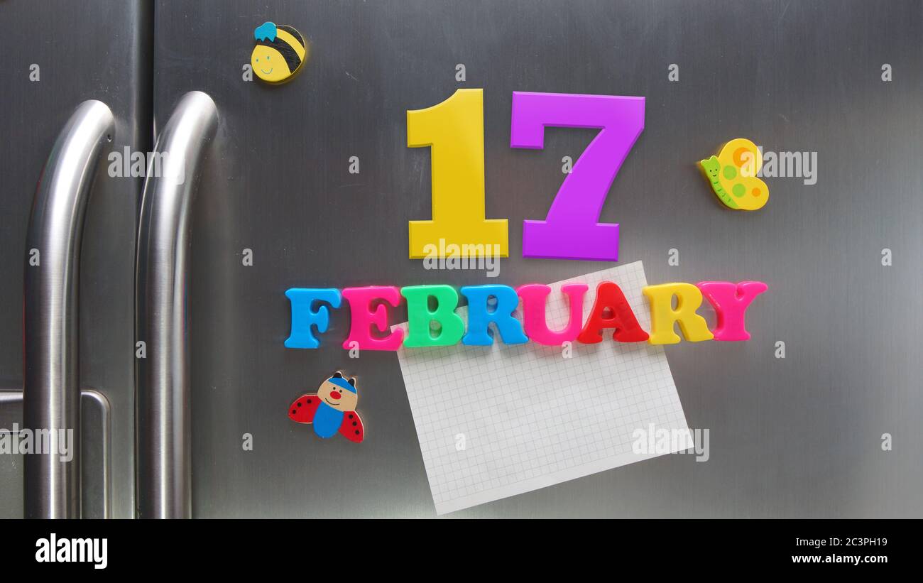 February 17 calendar date made with plastic magnetic letters holding a note of graph paper on door refrigerator Stock Photo