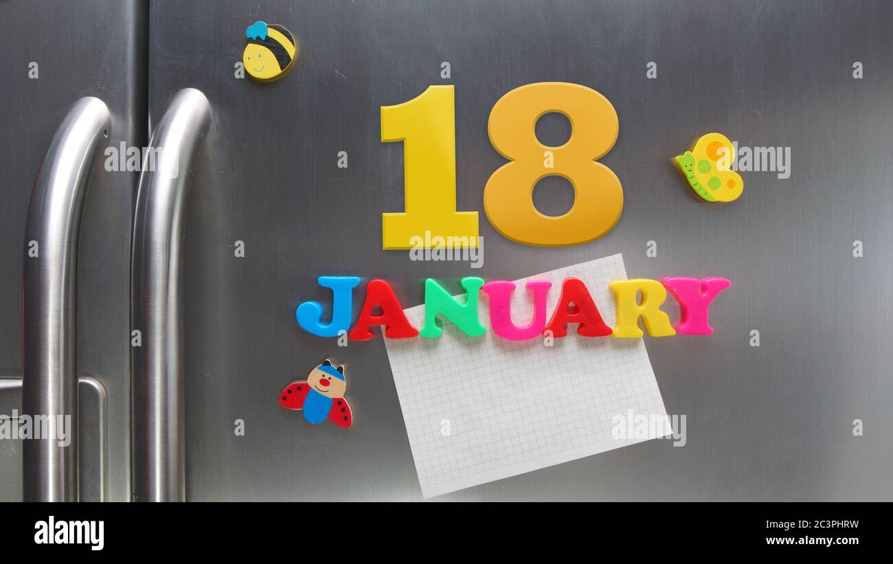 January 18 calendar date made with plastic magnetic letters holding a note of graph paper on door refrigerator Stock Photo