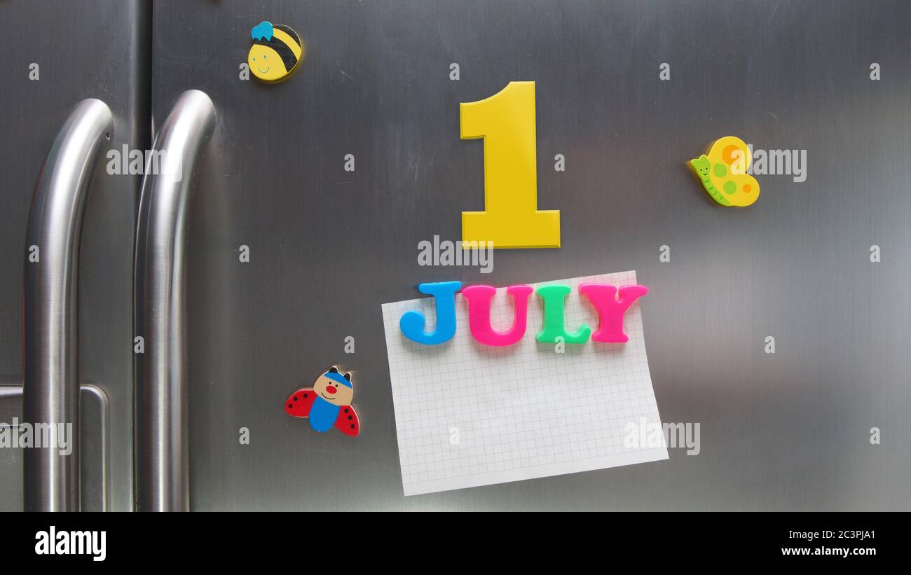 July 1 calendar date made with plastic magnetic letters holding a note of graph paper on door refrigerator Stock Photo