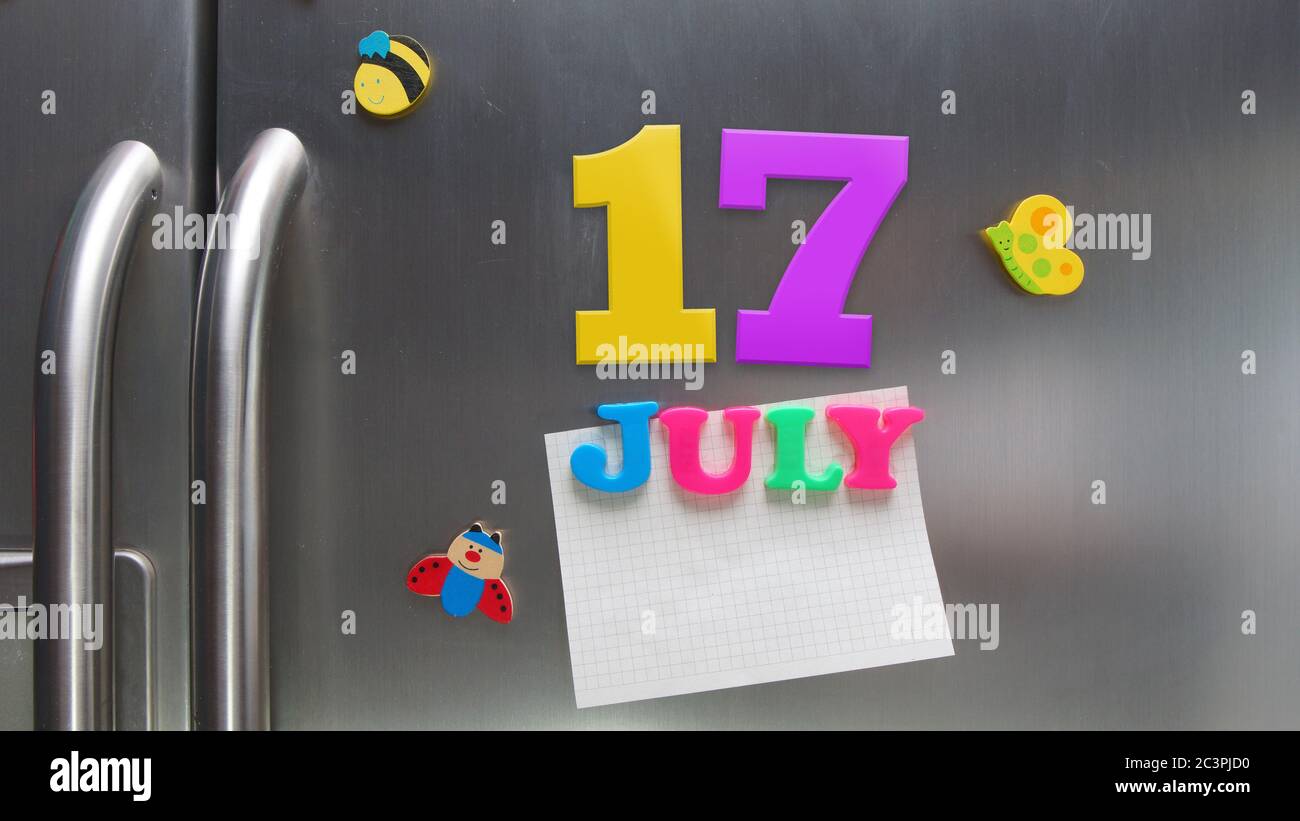 July 17 calendar date made with plastic magnetic letters holding a note of graph paper on door refrigerator Stock Photo