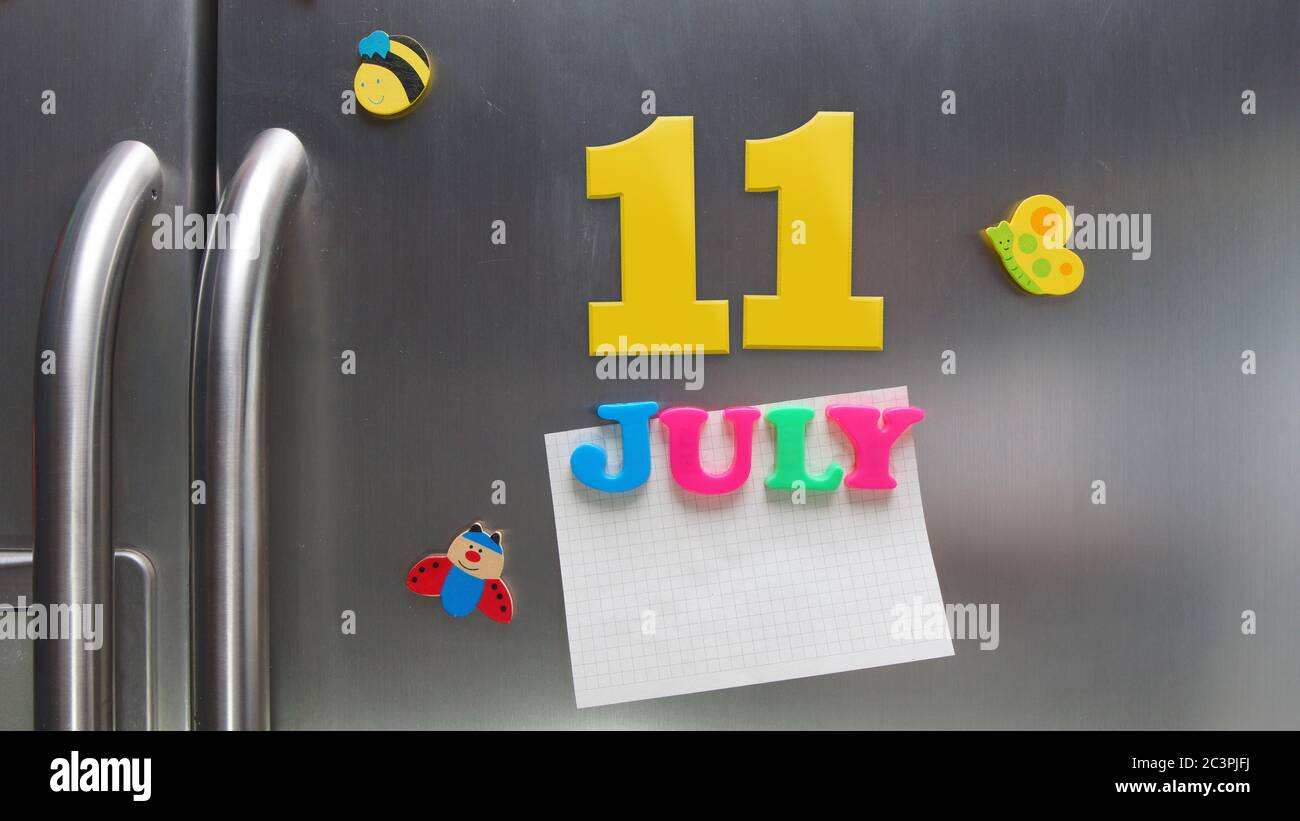 July 11 calendar date made with plastic magnetic letters holding a note of graph paper on door refrigerator Stock Photo