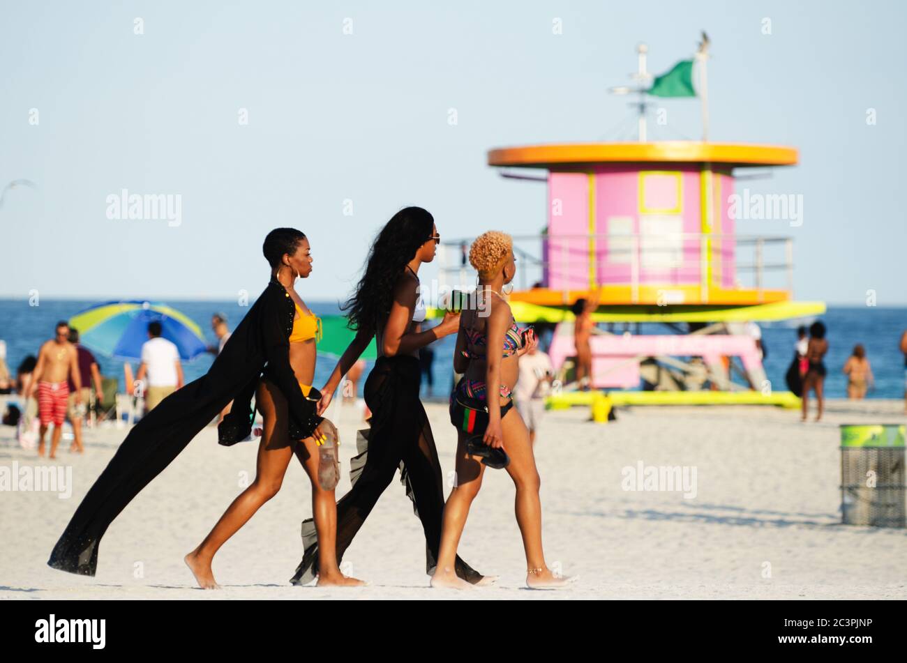MIAMI - MARCH 16, 2019: A group of young women walk toward a gathering of college students celebrating spring break on South Beach. Stock Photo