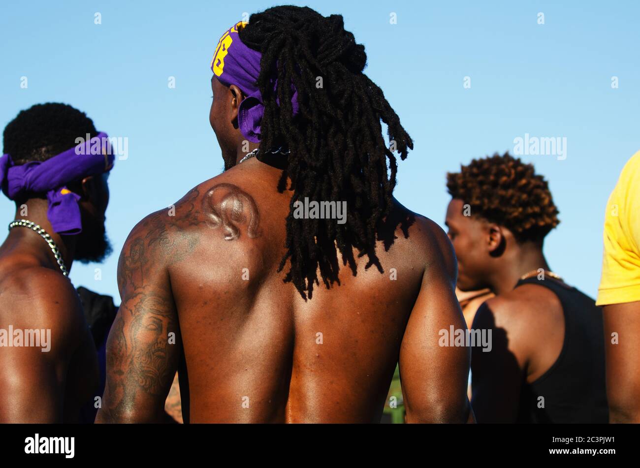MIAMI - MARCH 23, 2019: Young men from the Omega Psi Phi fraternity stand in the crowd at a Spring Break party on South Beach. Stock Photo