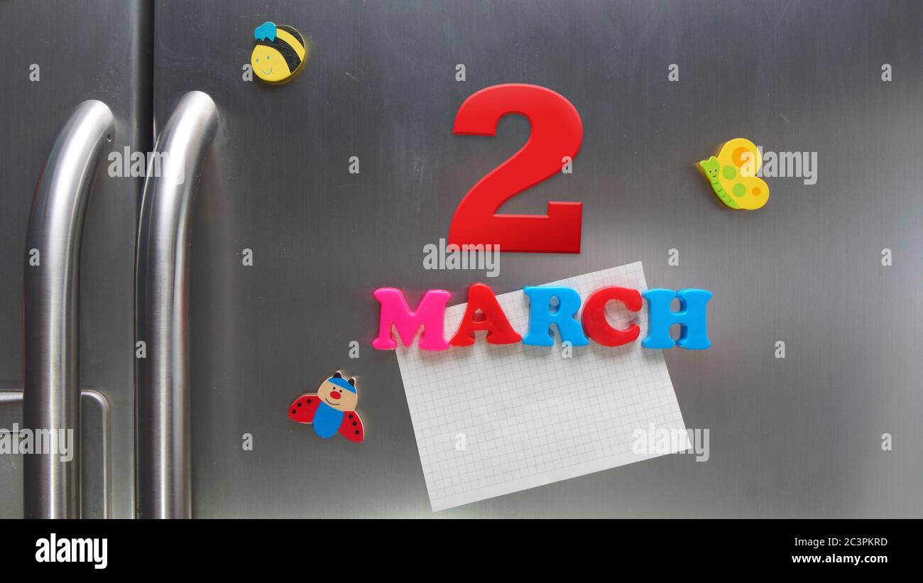 March 2 calendar date made with plastic magnetic letters holding a note of graph paper on door refrigerator Stock Photo