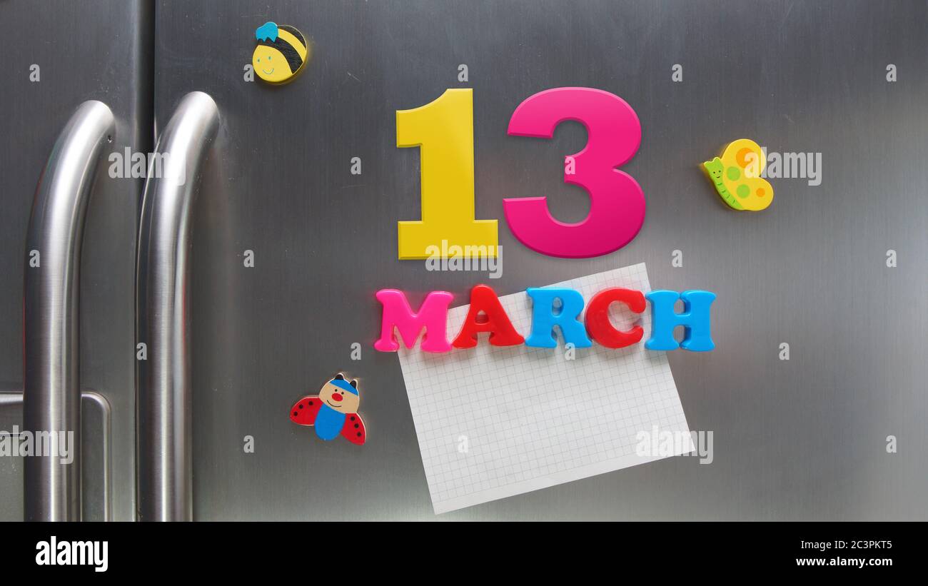 March 13 calendar date made with plastic magnetic letters holding a note of graph paper on door refrigerator Stock Photo