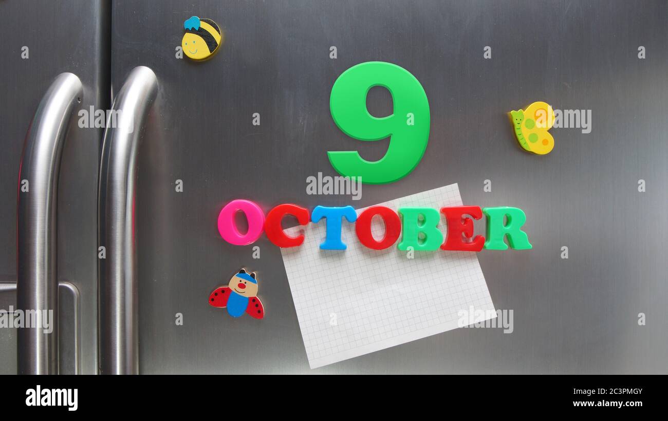 October 9 calendar date made with plastic magnetic letters holding a note of graph paper on door refrigerator Stock Photo