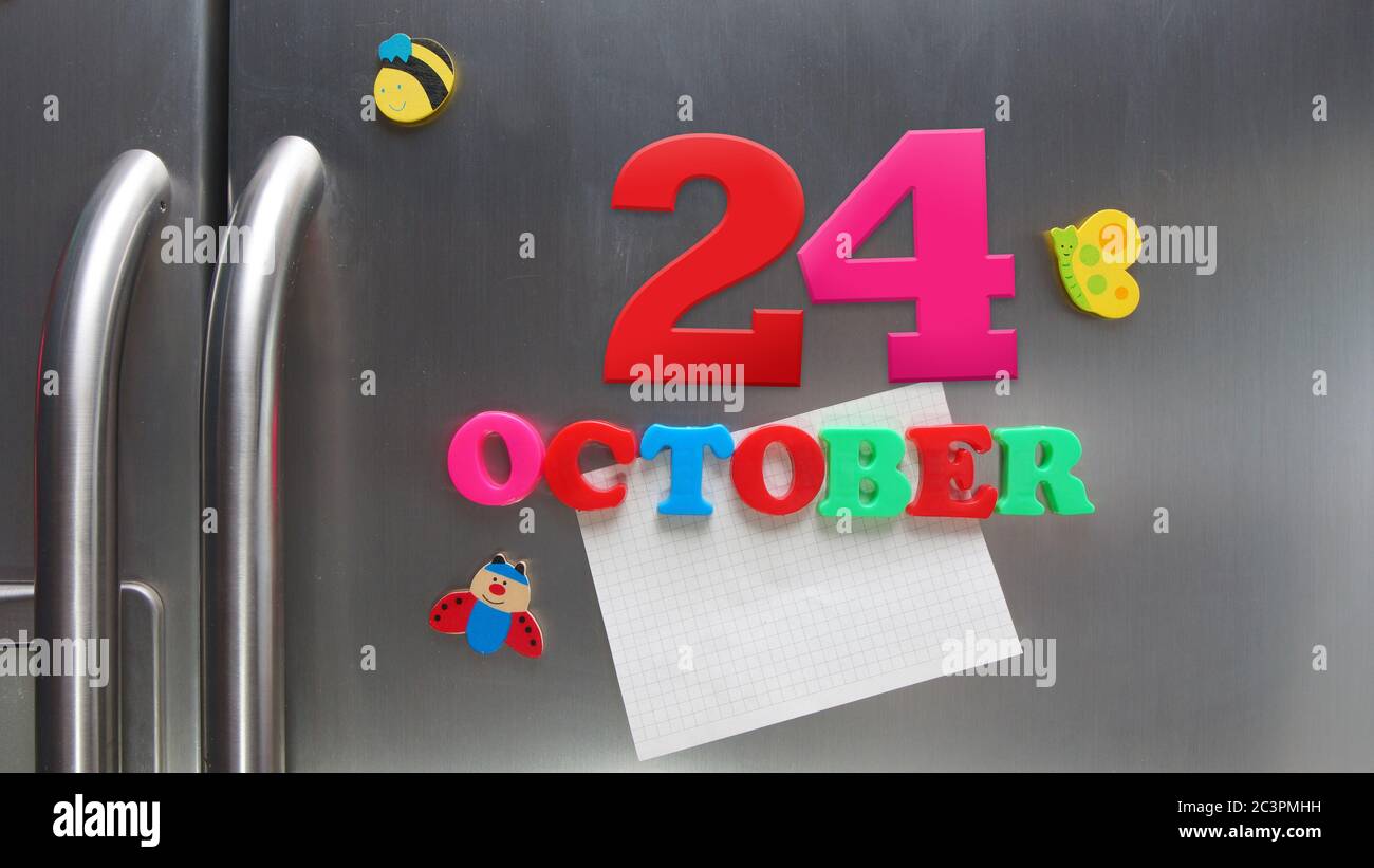 October 24 calendar date made with plastic magnetic letters holding a note of graph paper on door refrigerator Stock Photo